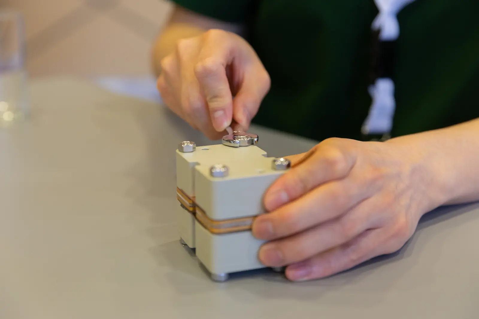 A person tightening a nut on the flow cell with a wrench